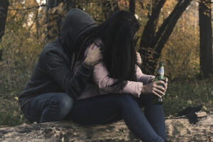 man hugging and consoling a crying girl experiencing the stages of alcoholism